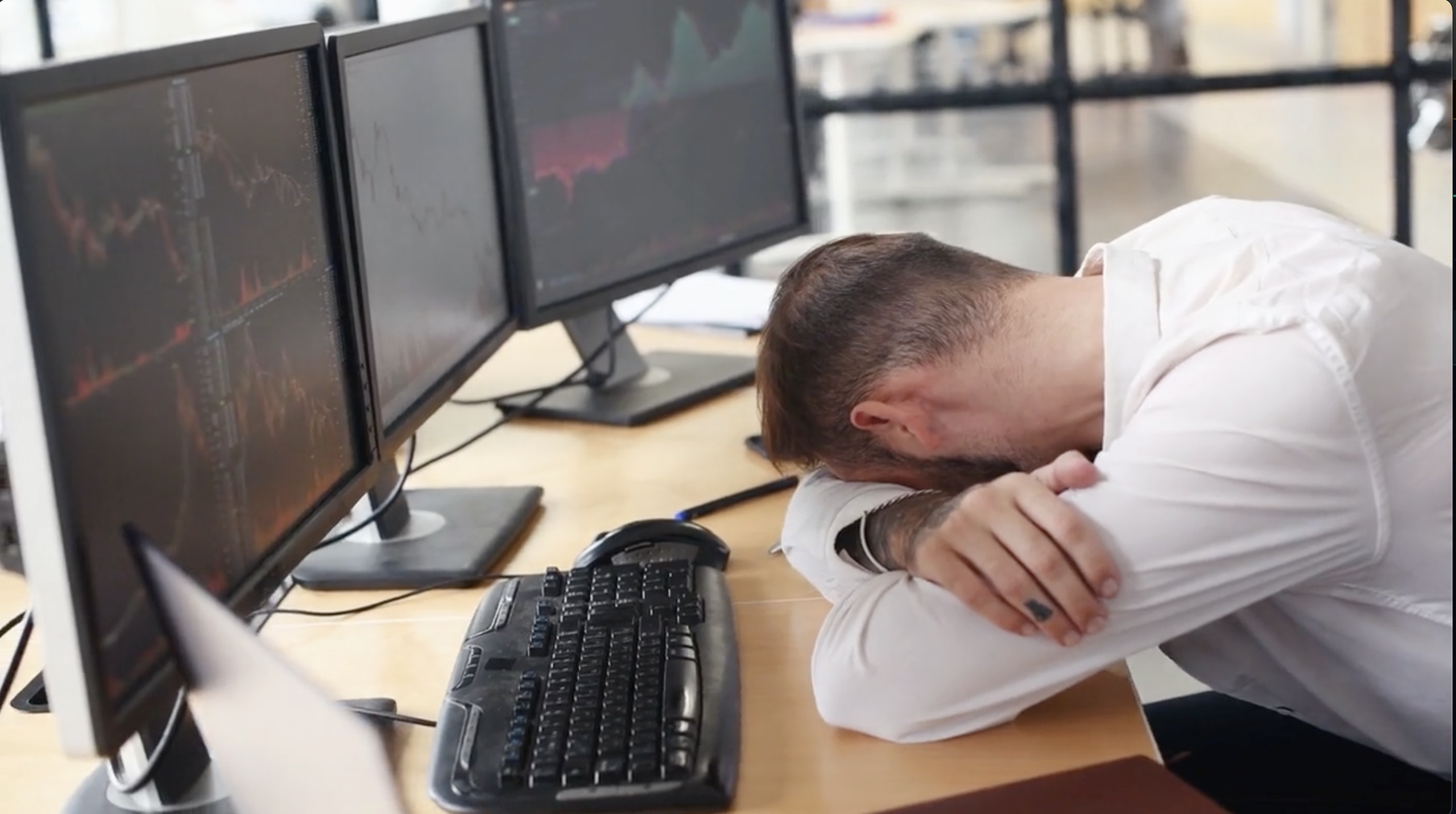 Two people looking at red charts on laptop