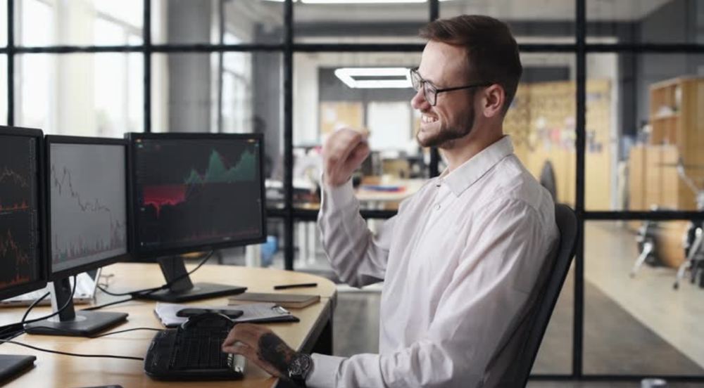 Trader at a multi-monitor desk